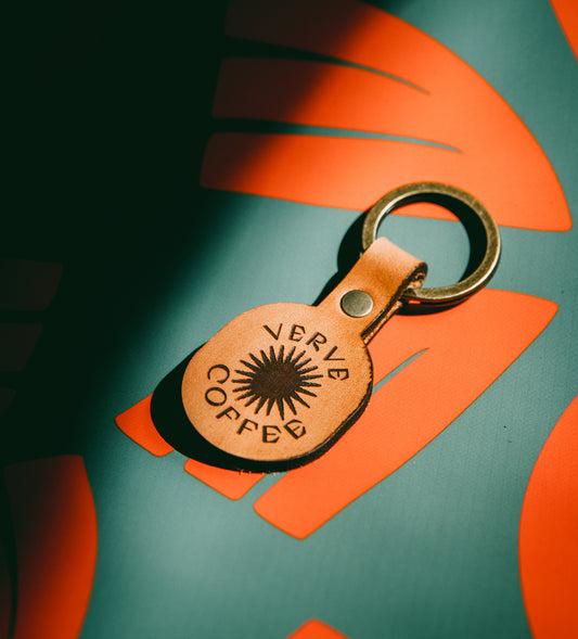 Radiant Burst Leather Keychain on holiday pattern background