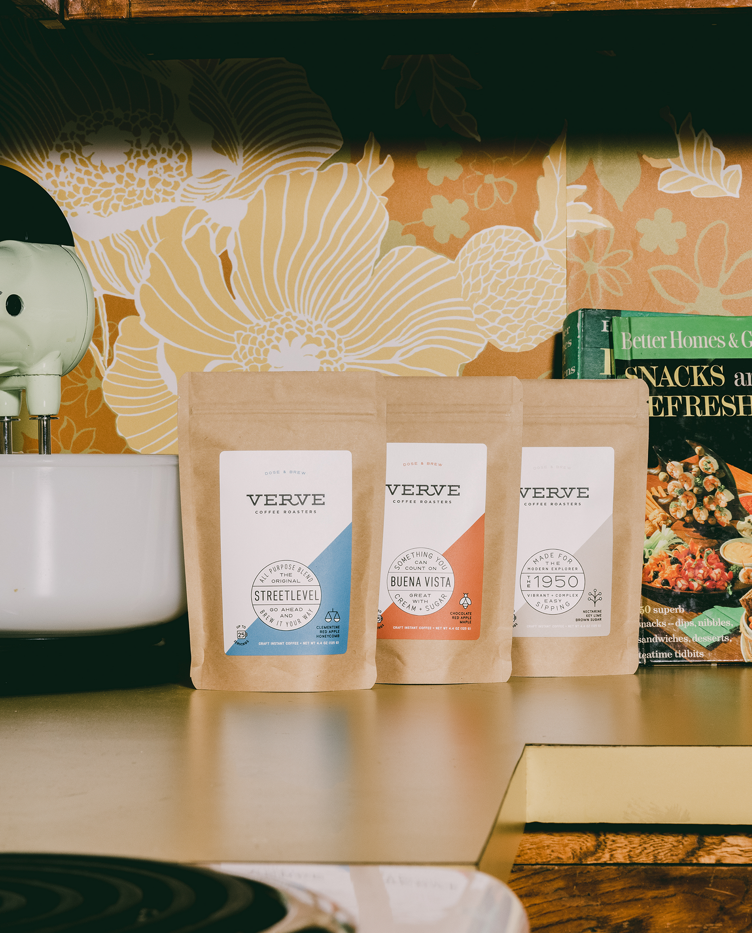 Dose and brew on a kitchen table next to cook books.